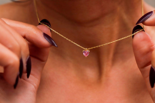 A woman wearing a delicate pink quartz, ametrine, and amethyst crystal choker necklace in silver tone.