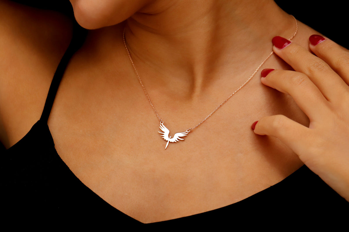 Necklace with a bird-shaped pendant worn by a person