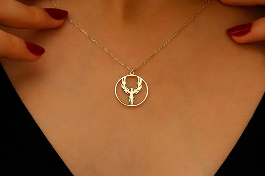 Gold necklace with a circular pendant featuring a deer design on a person's neck.