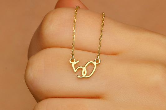 Three personalized interlock lucky numbers necklacesa 50 in gold,, displayed on a hand.