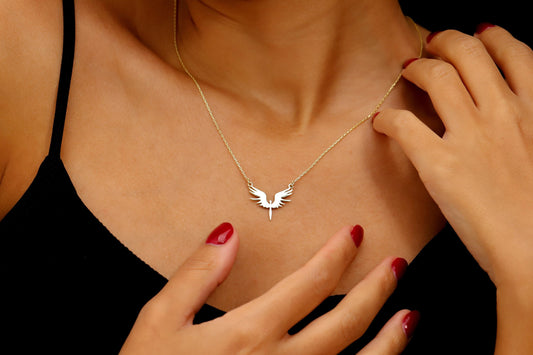 Necklace with a bird-shaped pendant worn by a person