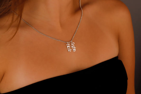 A close-up image of a woman wearing a silver name necklace with the name 'Alice' on it, showcasing the necklace on her collarbone.