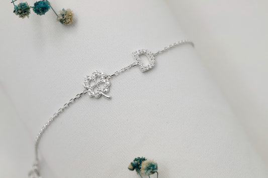 Silver bracelet with floral design on a light gray background