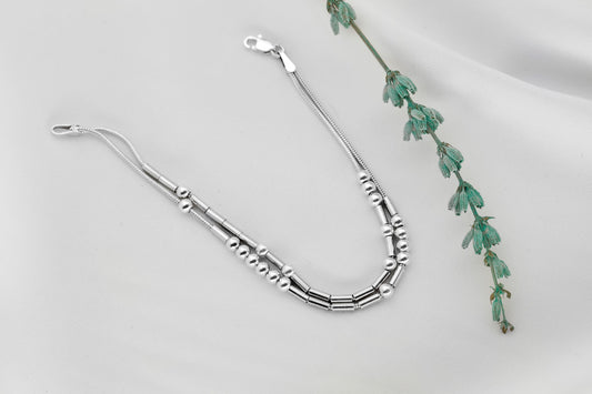 925 Sterling Silver Morse Code Bracelet with two strands hidden message, displayed on a white background next to a small green plant.