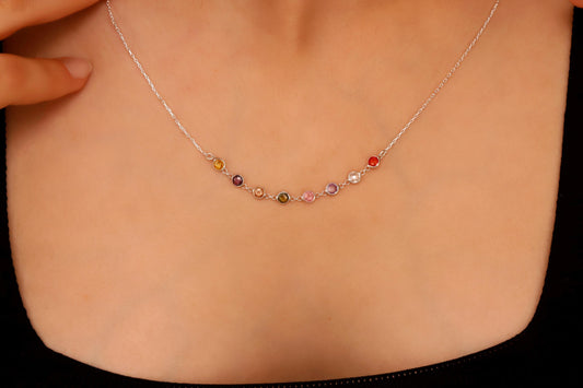 Necklace with multicolored beads worn by a person on a plain background