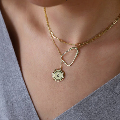 on https://silvergoldandrose.com/ . Gold necklace with a heart-shaped pendant and round pendant on a person wearing a gray top. Pulse Heart Stethoscope Necklace - Elegant Design Celebrating Healthcare Heroes