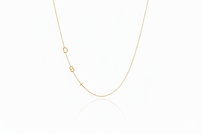 Gold necklace with small geometric pendants on a white background