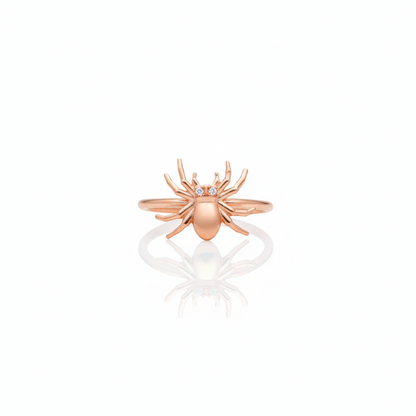Rose gold spider ring with small stones on a white background