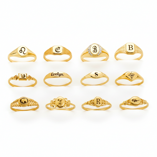 Collection of gold rings with various designs and initials on a white background