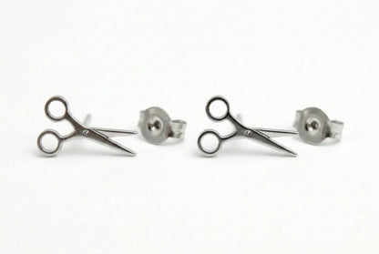Pair of silver scissors-shaped earrings on a white background