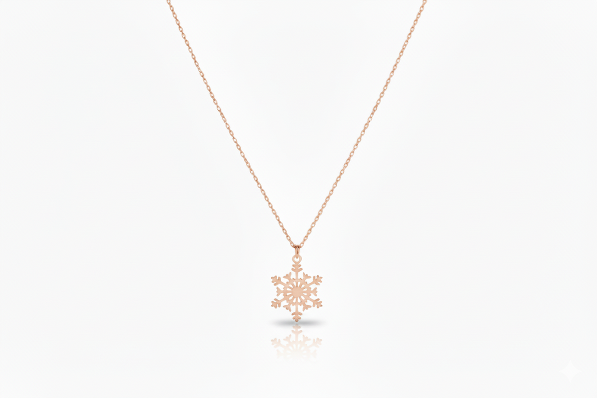 Rose gold snowflake pendant necklace on a white background