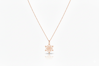 Rose gold snowflake pendant necklace on a white background