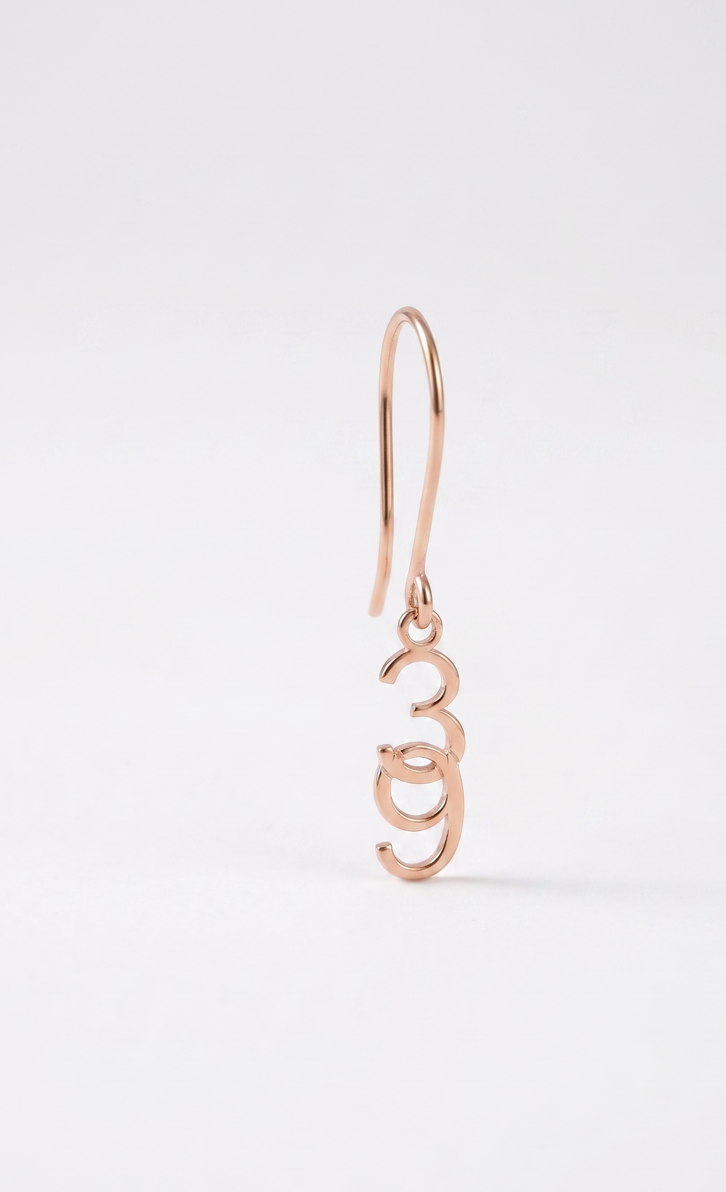 Rose gold earring on a white background