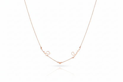 Rose gold necklace with 'love' engraving on a white background