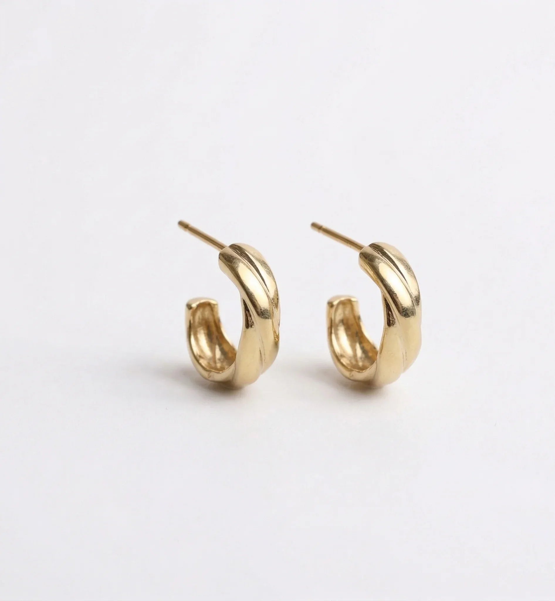 Pair of gold hoop earrings on a light gray background