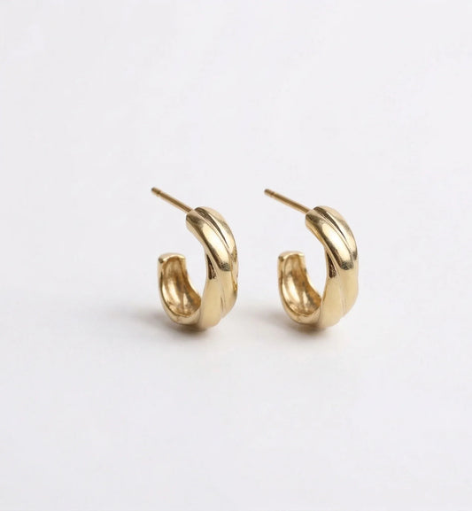 Pair of gold hoop earrings on a light gray background
