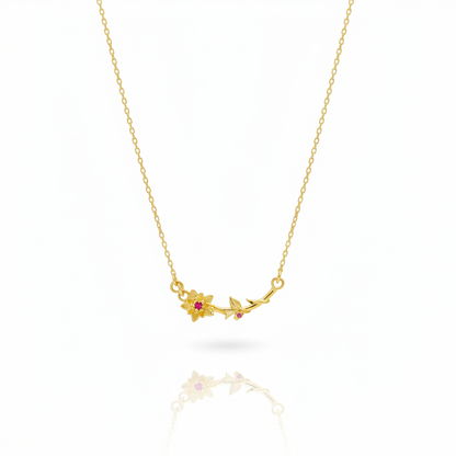 Gold necklace with floral pendant on a white background