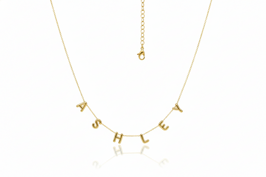 Gold necklace with 'ASHLEY' letters on a white background