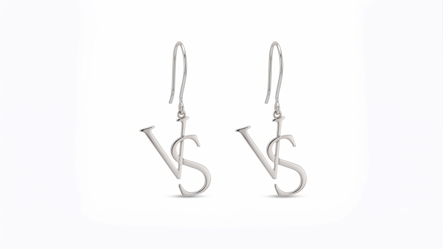 A pair of silver drop earrings featuring a stylized interlocking 'VS' monogram design, suspended from classic fishhook wires on a clean white background.
