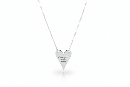 Heart-shaped silver necklace with engraved text on a white background