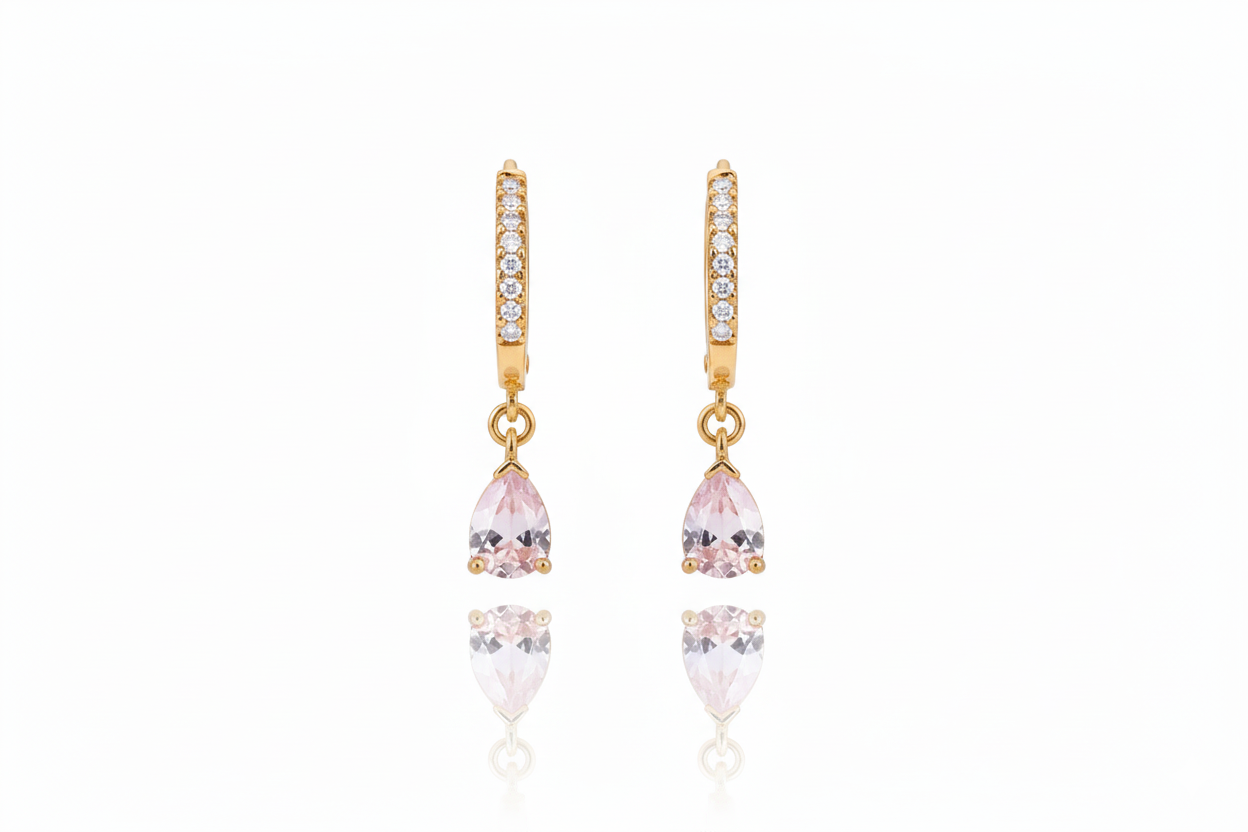 Gold earrings with pink and clear gemstones on a white background