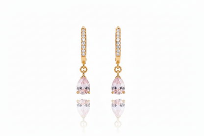 Gold earrings with pink and clear gemstones on a white background