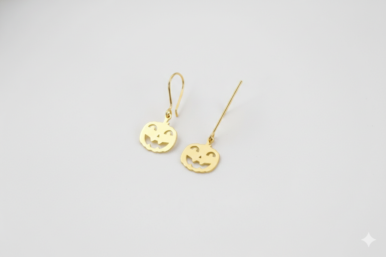 Pair of gold earrings on a light gray background