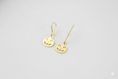 Pair of gold earrings on a light gray background
