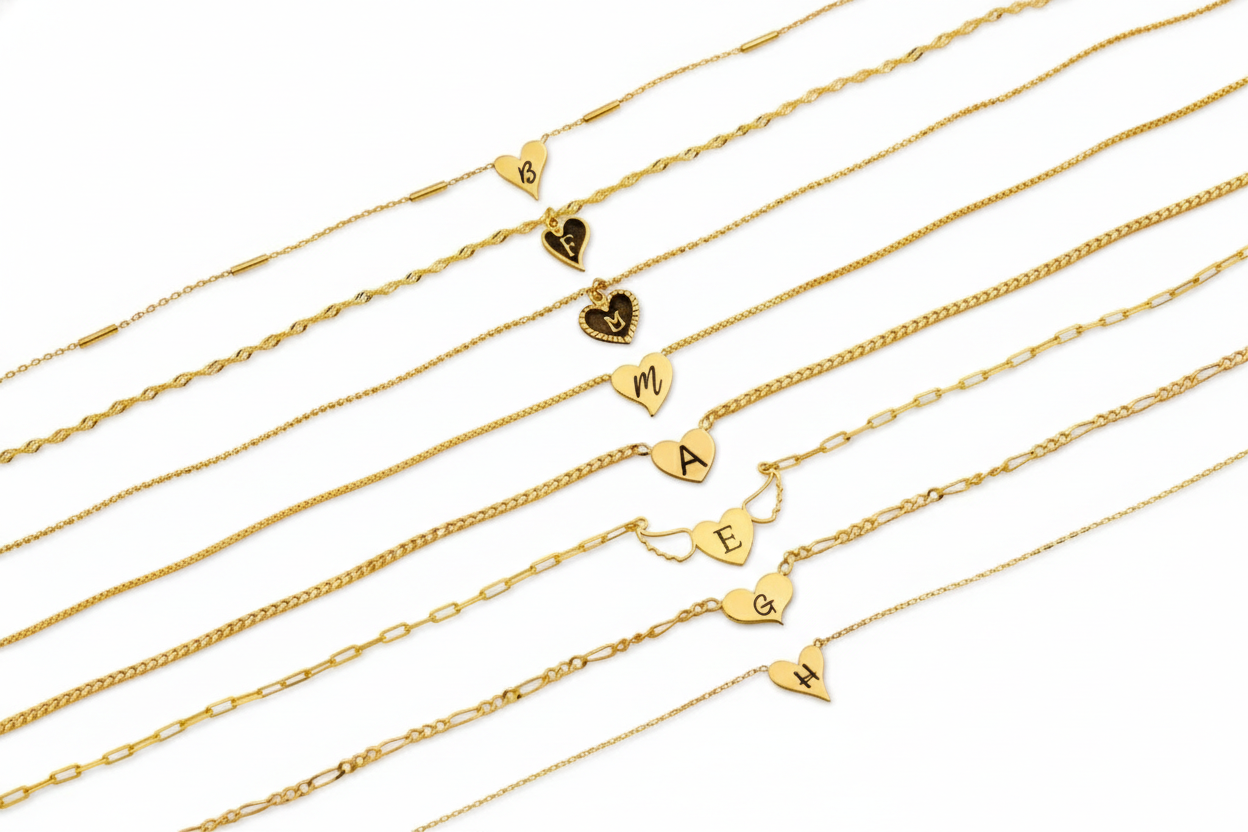Set of gold necklaces with heart-shaped charms on a white background