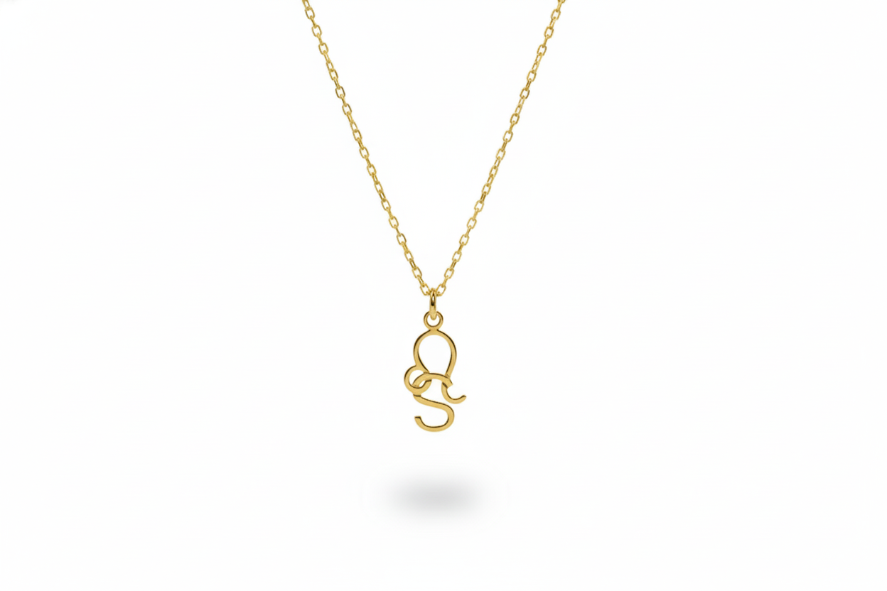 Gold necklace with a small pendant on a white background
