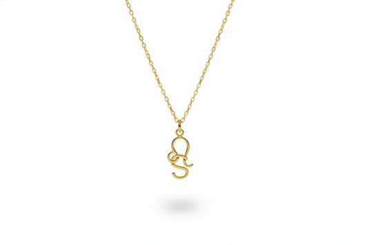 Gold necklace with a small pendant on a white background