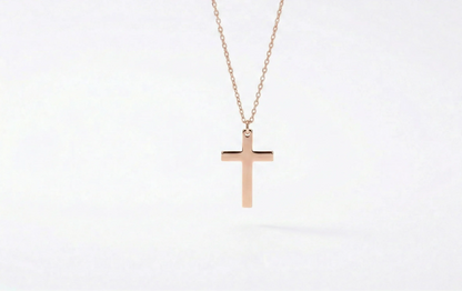 Rose gold cross necklace on a white background