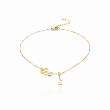 Gold bracelet with key charm on a white background