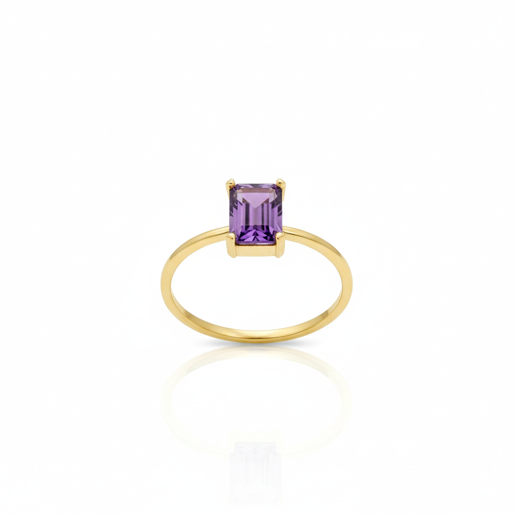 Gold ring with a purple gemstone on a white background