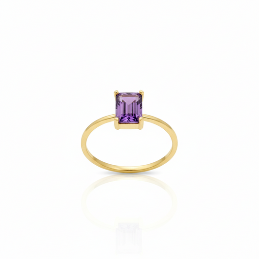 Gold ring with a purple gemstone on a white background