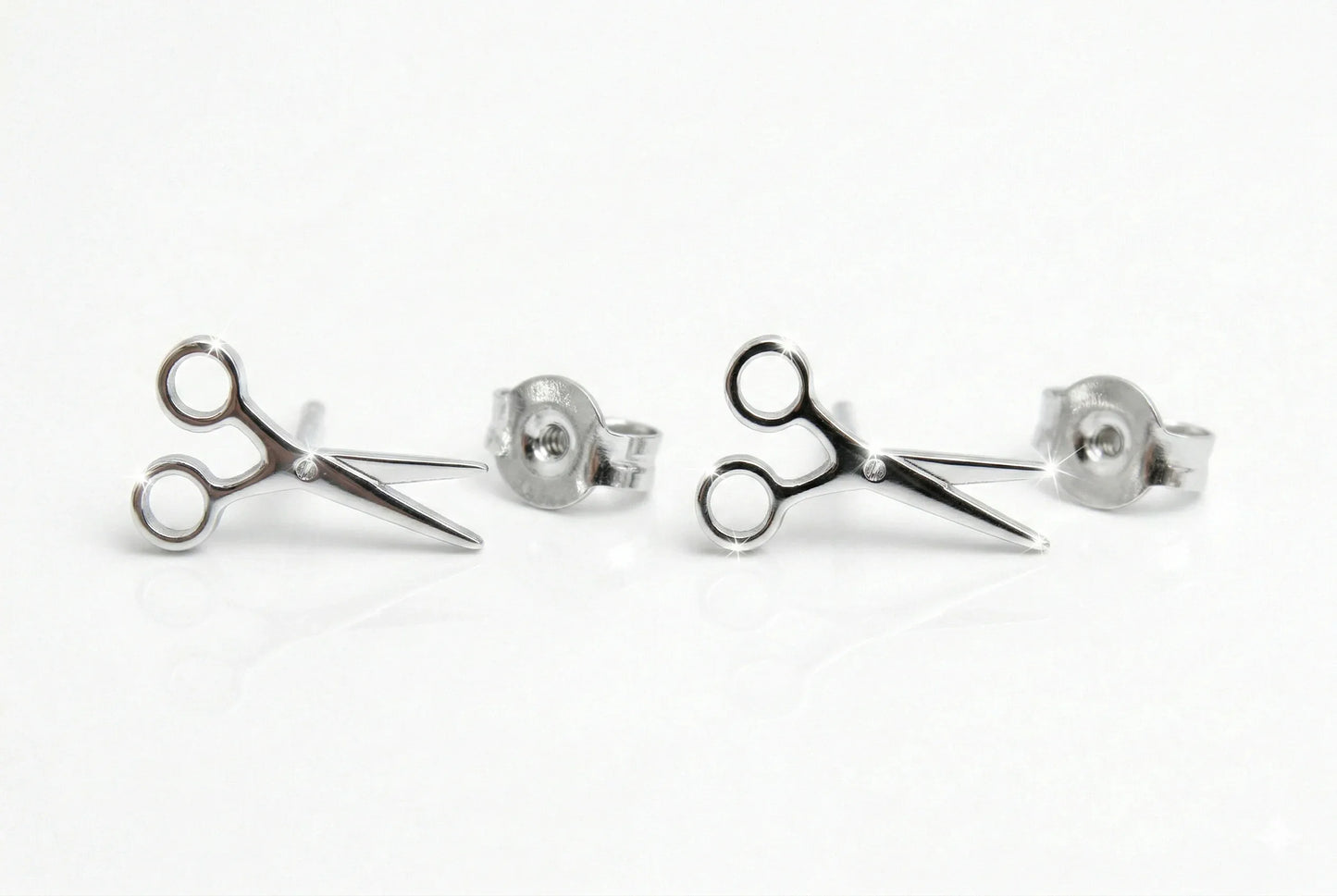 Scissor-shaped stud earrings on a white background