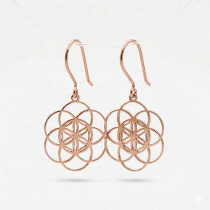 Rose gold earrings with intricate design on a light gray background