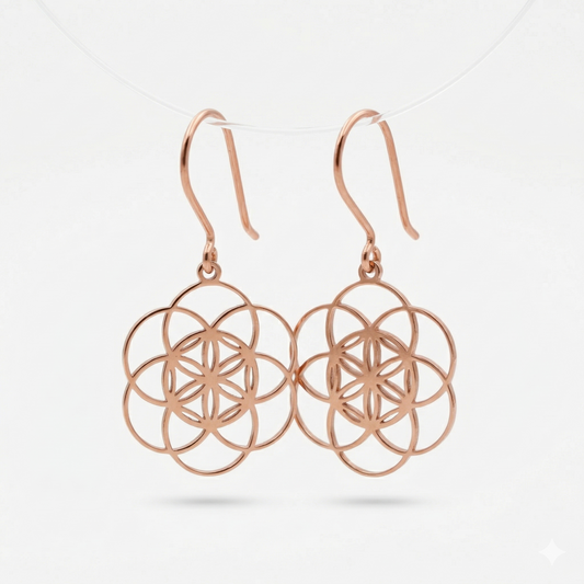 Rose gold earrings with intricate design on a light gray background