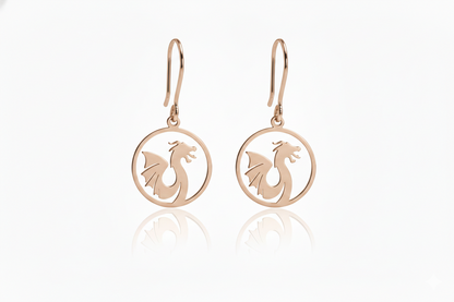 Rose gold earrings with dragon design on a white background