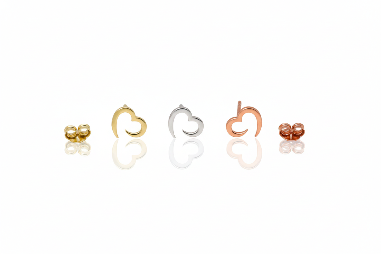 Set of heart-shaped earrings in gold, silver, rose gold on a white background