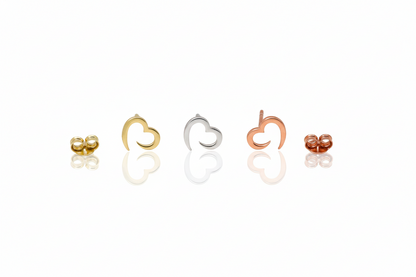 Set of heart-shaped earrings in gold, silver, rose gold on a white background