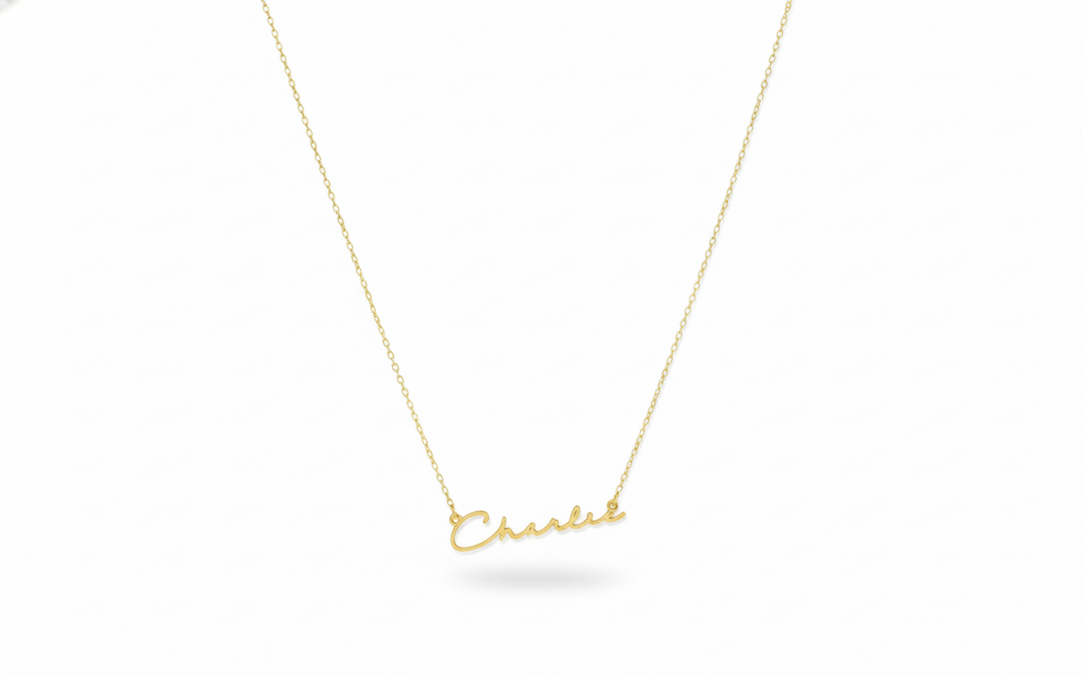 Gold necklace with 'Chanel' pendant on a white background