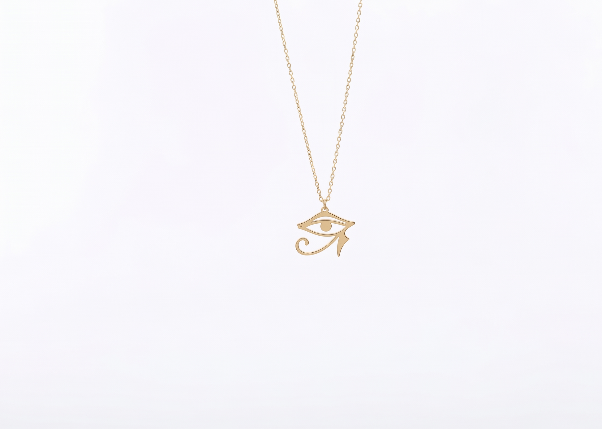 Gold necklace with an eye-shaped pendant on a white background