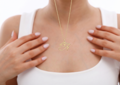 Gold necklace with a pendant worn by a person against a white background