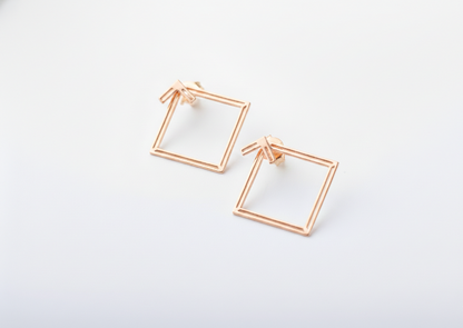 Rose gold square frame earrings on a white background