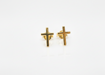 Gold cross-shaped earrings on a white background