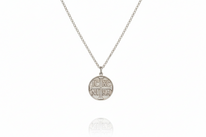 Silver necklace with a round pendant on a white background