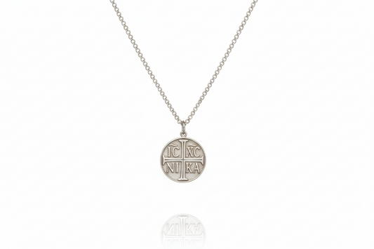 Silver necklace with a round pendant on a white background