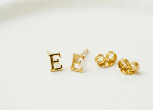 Gold letter 'E' earrings on a white background