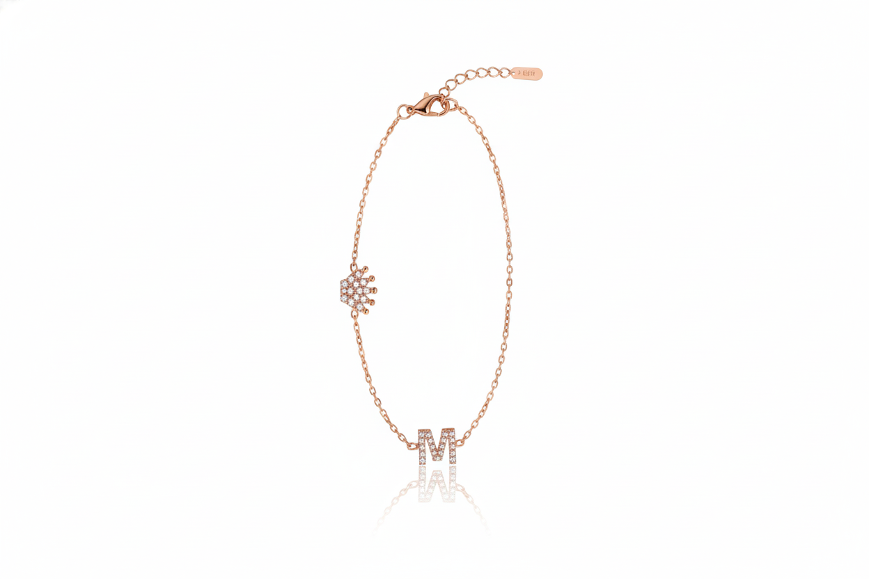 Rose gold bracelet with letter 'M' charm on a white background